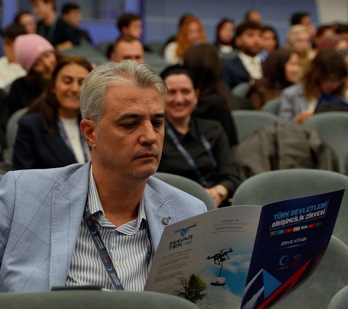 Zirvede broşürü inceleyen katılımcı