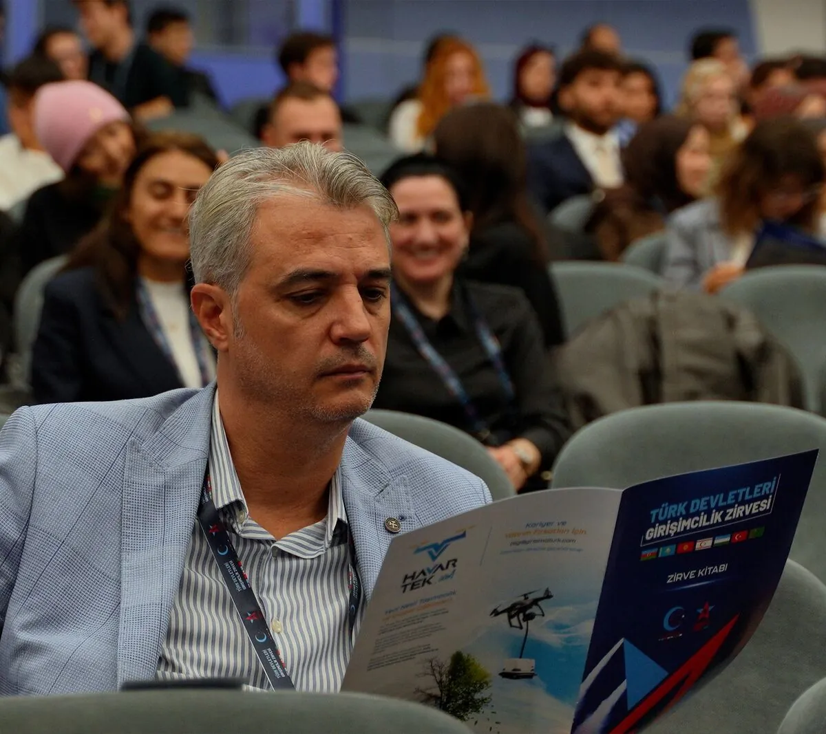 Zirvede broşürü inceleyen katılımcı